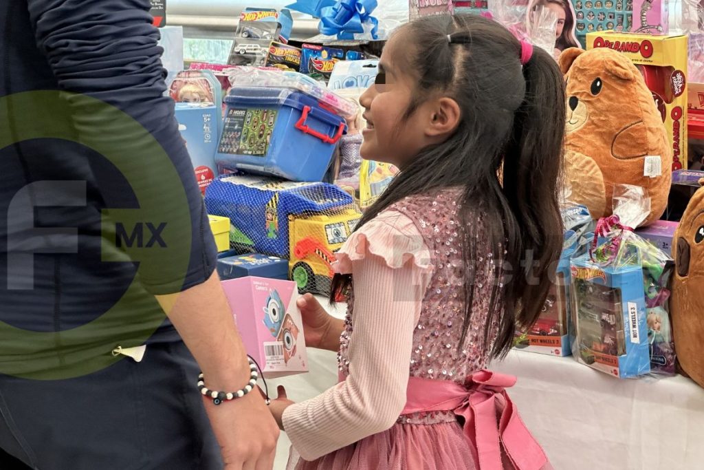 Niña elige juguetes en evento para niños con cáncer en Toluca