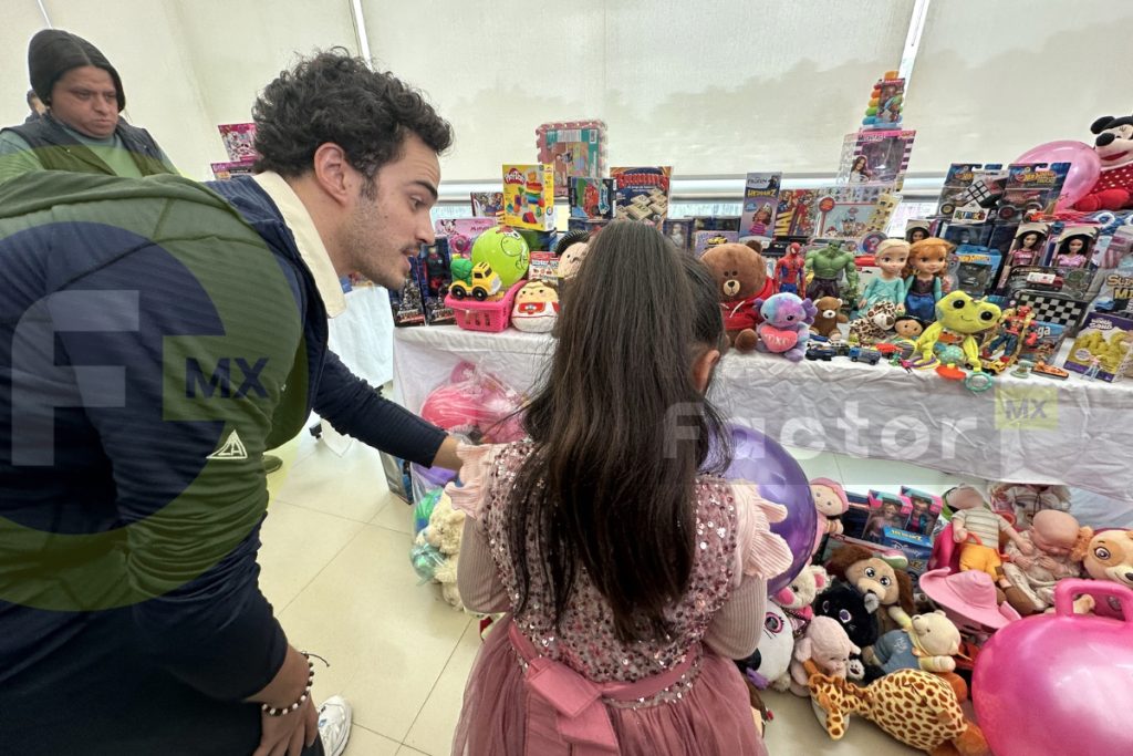 Una niña recibe un juguete durante la celebración del Día del Niño en Toluca.