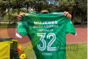 Activista muestra una camiseta verde con la leyenda “Mujeres buscadoras, campeonas en 32 estados”.